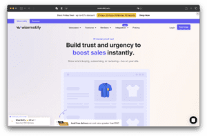 หน้าแรกของเว็บไซต์ของ Wisernotify แสดงพาดหัวข่าวเกี่ยวกับการสร้างความไว้วางใจและการปรับปรุงยอดขายเมนูการนําทางที่ด้านบนภาพผลิตภัณฑ์เสื้อสีน้ําเงินและกราฟิกร้านค้าออนไลน์